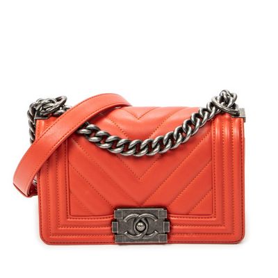 a small orange quilted bag with a chain strap