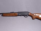 un fusil avec un canon en bois sur fond blanc