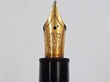 the tip of a fountain pen that is sitting on top of a table