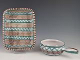 two pieces of pottery sitting on top of a table next to each other
