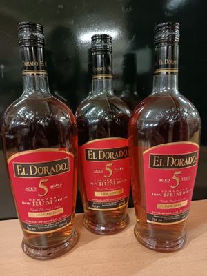 Trois bouteilles de whisky El Dorado 5 ans d'âge sont posées sur une table