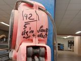 une bouche d'incendie rose fixée à un poteau dans un entrepôt