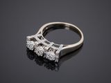 a three stone diamond ring on a black surface