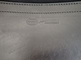 the back of a black leather purse with a small logo on it