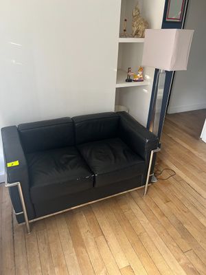 un canapé en cuir noir dans un coin du salon