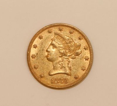 a close up of a gold coin with a woman ' s head on it
