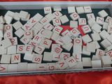 a box of scrabbles on a table with a red cloth