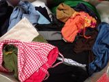 a suitcase full of clothes and clothes sitting on the floor
