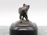 a bronze statue of a dog on a marble base