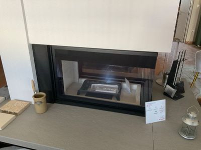 une cheminée avec un verre de vin sur la table