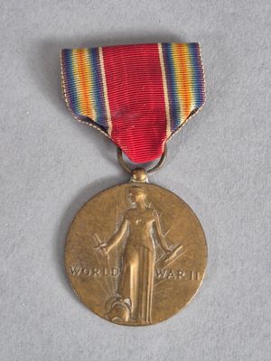 une vieille médaille entourée d'un ruban, posée sur un fond blanc