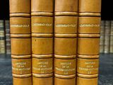 une rangée de vieux livres posés sur une étagère en bois