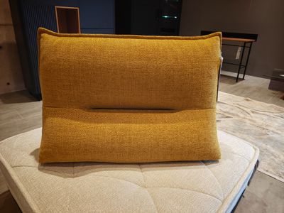 a yellow pillow sitting on top of a mattress