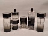 several bottles of different types of perfume sitting on a white surface