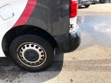 a white van with a red and black stripe parked in a parking lot