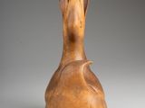 a close up of a wooden vase on a white surface