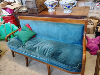 un canapé bleu sur lequel repose un coussin vert, dans une pièce