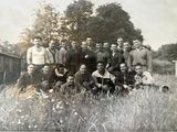 un groupe d'hommes posant pour une photo dans un champ