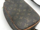 un gros plan d'un sac à bandoulière Louis Vuitton posé sur une surface blanche