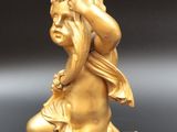 gold statue of a woman carrying a bird on her back