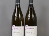 two bottles of wine sitting on top of a table next to each other