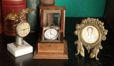 three clocks and a picture frame on a table