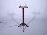 une petite table sur laquelle se trouvent trois bougies et une lampe posée dessus