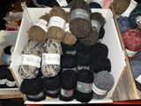 many balls of yarn in a box on a table
