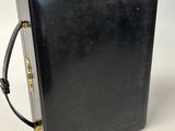 a black briefcase with a gold handle on a white background
