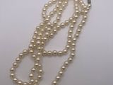 gros plan d'un collier de perles blanches sur une surface blanche
