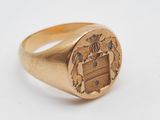 un gros plan d'une bague en or sur laquelle est gravé un blason