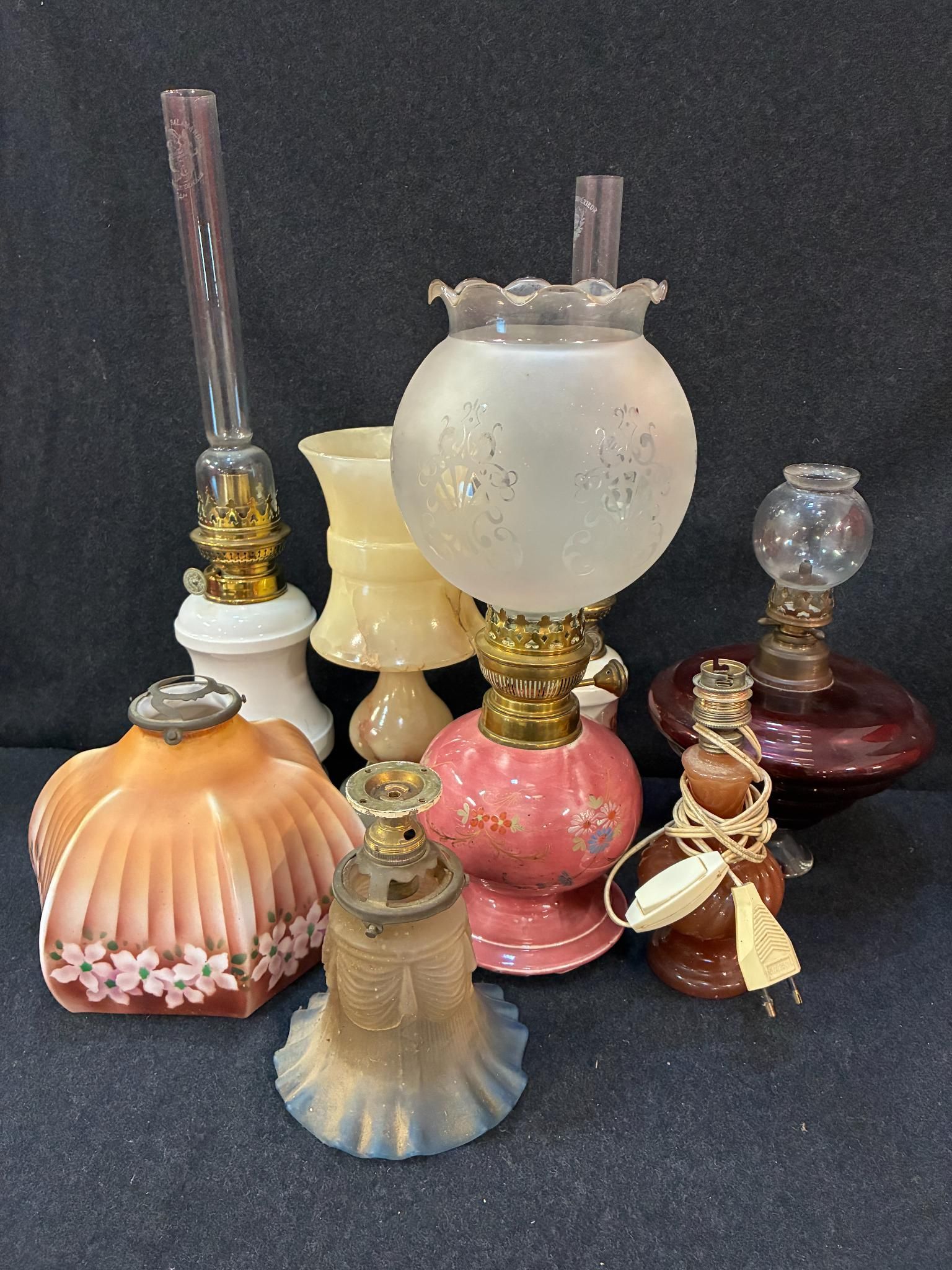 Lot comprenant quatre lampes à pétrole dont d'une à forme de…