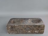 an old stone sink sitting on top of a white table