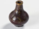 a small brown vase sitting on a white surface