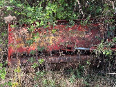 an old red truck that is sitting in the grass