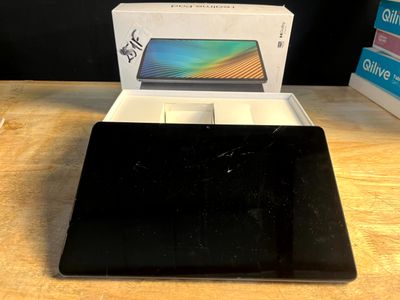un ordinateur portable posé sur une table, à côté d'une boîte
