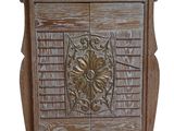 une photo d'un meuble en bois dont la porte est ornée d'un motif sculpté