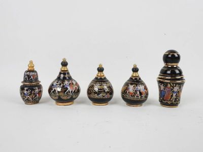 Ensemble de cinq flacons à parfum en céramique à fond noir.