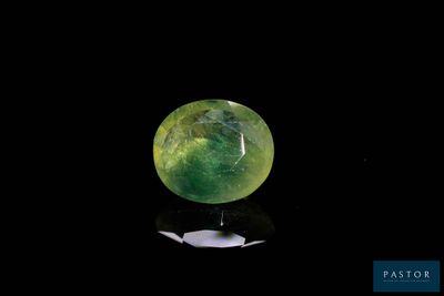 a close up of a green jade ball on a black surface