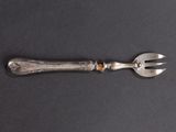 a silver spoon and a fork on a black surface