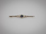 une broche en forme de barre sertie d'un saphir bleu et de diamants