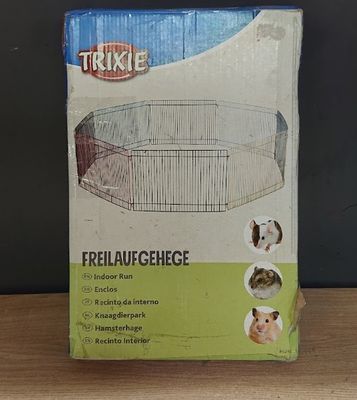 une boîte contenant une petite cage pour animaux, posée sur une table en bois