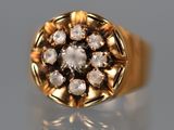 un gros plan d'une bague en or sertie de diamants sur une surface réfléchissante