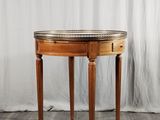 une petite table avec un plateau en marbre sur un plancher en bois
