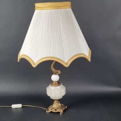 a white lamp with gold trim and a white shade