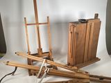 une photo représentant un ensemble de chevalets en bois et une boîte de peinture