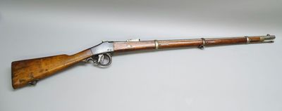 un vieux fusil avec un canon en bois et une poignée en métal