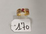 Gros plan sur une bague en or ornée d'une pierre rouge