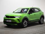 un SUV vert garé dans une pièce au sol carrelé