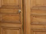 a gold floor lamp on a wooden floor in front of a wooden door